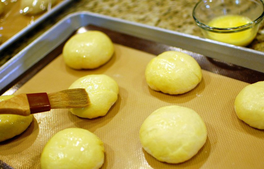 1. Этап. Японская выпечка: Выкладывайте пирожки на застеленный пергаментом противень. Каждый из пирожков смажьте желтком.