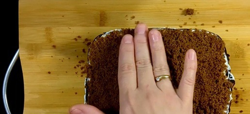 1. Этап. Шоколадный десерт с нежным творожным кремом: Теперь нам нужно создать дно десерта. Для этого используем вторую отрезанную часть бисквита. Достаточно тяжело испечь бисквит так, чтобы он по форме подходил к дну шоколадной формы, поэтому разрезав на кусочки измельчаем бисквит с помощью блендера и получившейся крошкой выкладываем дно десерта. Хорошо прижимаем лопаткой или руками, что бы крошка не отваливалась.