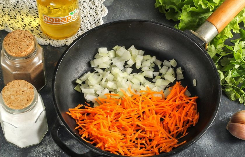1. Этап. Сырный суп с пельменями: Морковь натрите на терке, а лук нарежьте мелким кубиком. Обжарьте овощные нарезки на сковороде в растительном масле примерно 3-5 минут.