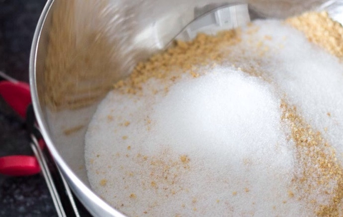 1. Этап. Чизкейк с желе: 1. Измельчите крекеры или песочное печенье в мелкую крошку. Добавьте 3 столовые ложки сахара и растопленное сливочное масло, перемешайте.