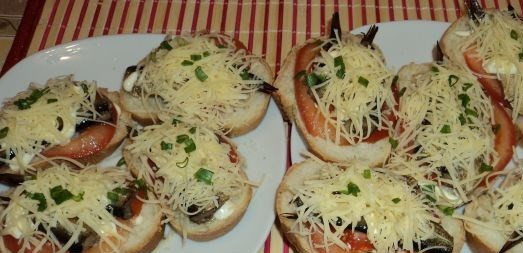 1. Этап. Горячие бутерброды со шпротами и сыром: Присыпаем шпроты сыром и кладем измельченный лук. Отправляем бутерброды в микроволновку, до полного расплавления сыра.