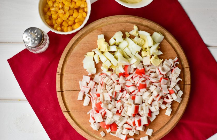 1. Этап. Салат с крабовыми палочками и копченой курицей: Нарежьте крабовые палочки и вареные куриные яйца кубиками.