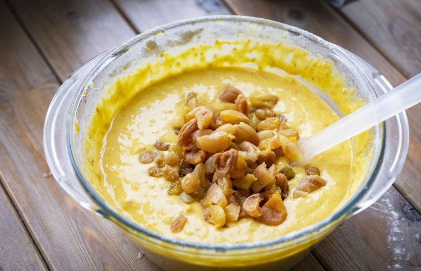 1. Этап. Тыквенно-овсяный пирог: К тесту добавьте изюм и нарезанную небольшими кусочками курагу. Вмешайте сухофрукты в тесто лопаткой.