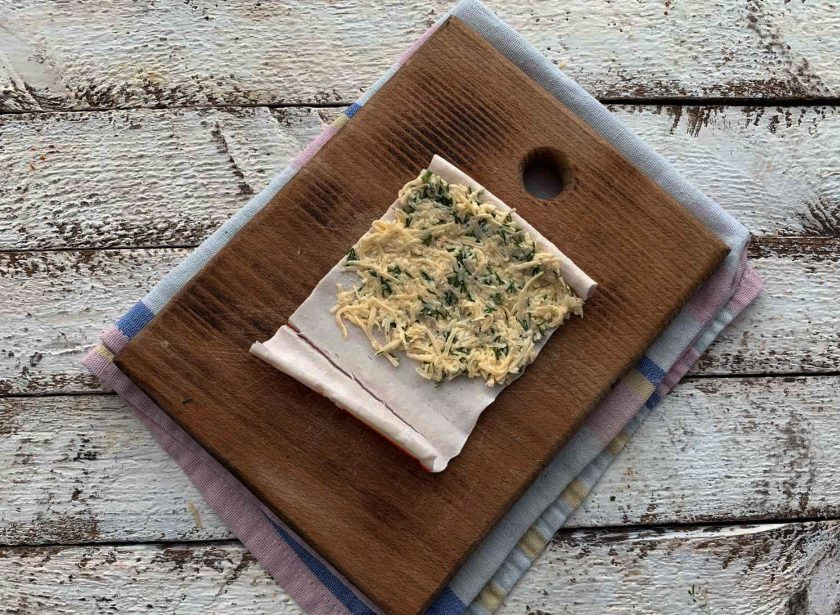 1. Этап. Салат Избушка из крабовых палочек: Крабовую палочку разверните и выложите на нее начинку. Чтобы палочки просто развернуть — выложите их в глубокую тарелку и залейте полностью кипятком. Конечно же, перед этим снимите полиэтиленовые упаковки с каждой палочки. Буквально 30-40 секунд и сливайте горячую воду. Оставьте палочки охладиться.