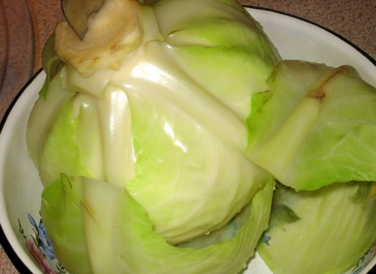 1. Этап. Голубцы по-украински: 2. Готовим листья. Для этого опускаем качан в подсоленную воду и варим его на среднем огне. Затем вытаскиваем и снимаем нужно количество листьев. При необходимости опускаем его снова в кипяток и проделываем ту же процедуру.