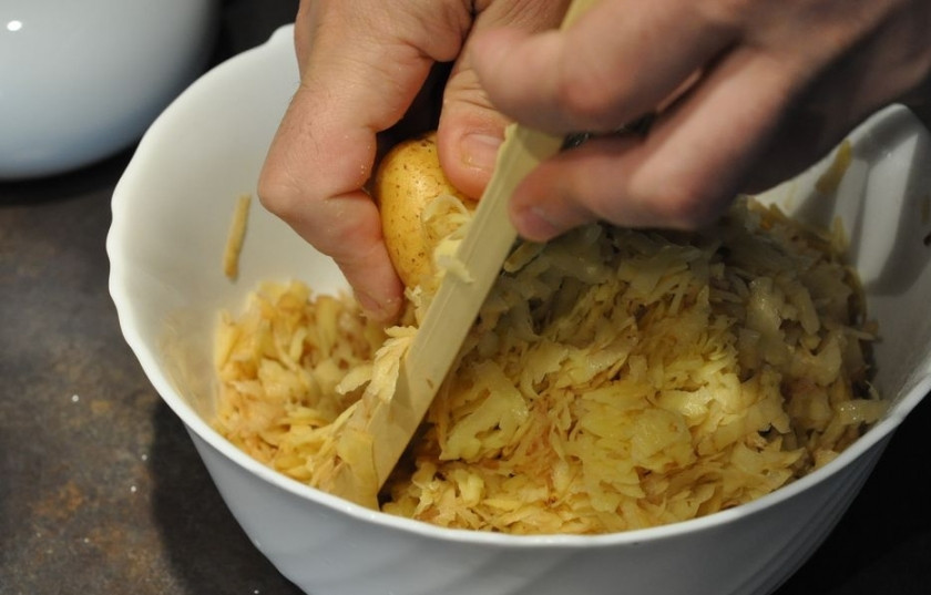 1. Этап. Драники по-белорусски: Теперь необходимо натереть картофель на терке. Если он молодой, то вы можете не очищать его от шкурки. После того как весь картофель будет подготовлен, отожмите его и слейте лишний сок.