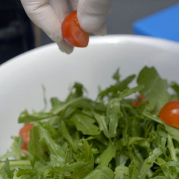 1. Этап. Салат с креветками Вкусный: Добавляем к рукколе разрезанные пополам помидоры черри.