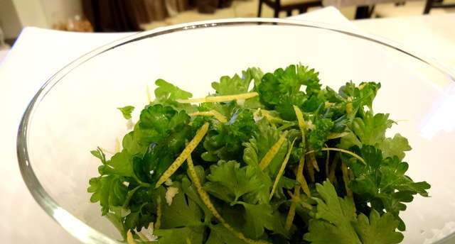 1. Этап. Тушеная голяшка: Измельчите один зубчик чеснока и петрушку. Добавьте к ним цедру, соль и перец. Перемешайте.