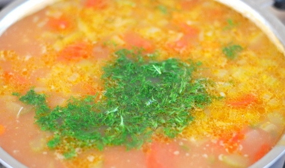 1. Этап. Перловый суп с солеными огурцами: 9. Вымойте зелень, мелко её нарежьте, добавьте томатную пасту и проварите еще 1-2 минуты.