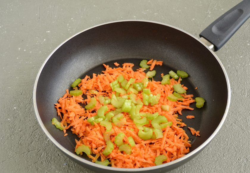1. Этап. Соевая запеканка: Морковь натрите на крупной тёрке, сельдерей нарежьте. Обжарьте овощи на среднем огне 3-4 минуты.