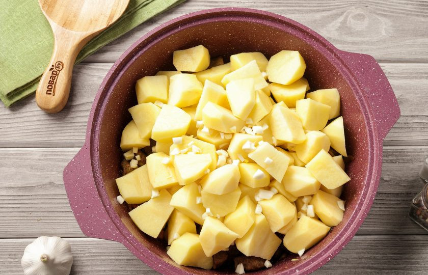 1. Этап. Тушёная картошка с мясом и баклажанами: Теперь добавьте нарезанный достаточно крупно картофель и чеснок, нарезанный мелкими кубиками.