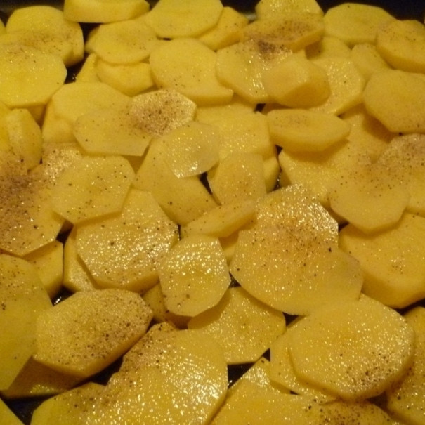 1. Этап. Мясо по-французски с картофелем: Картофель чистим, режем на тонкие пластины и укладываем на противень, смазанный маслом.