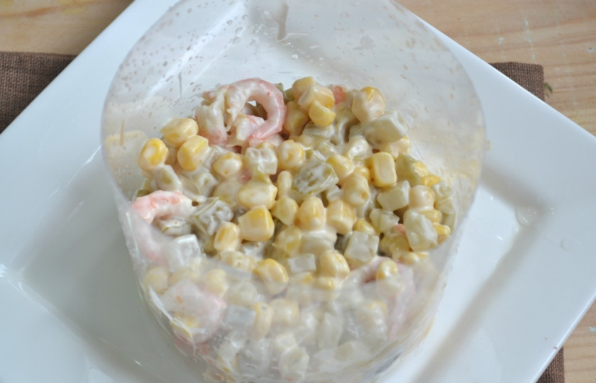 1. Этап. Салат с креветками и икрой: Выложите салат в сервировочное кольцо (у меня его функцию выполняет обрезанная пластиковая бутылка) на плоскую тарелку. Разровняйте, слегка придавите ложкой. Аккуратно снимите сервировочное кольцо.