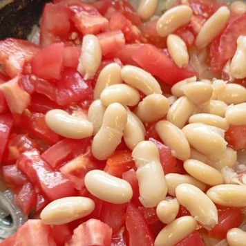 1. Этап. Грудки индейки в фольге: Лук нашинкуйте тонкими полукольцами. Помидоры очистите от кожица и нарежьте небольшими кубиками. С фасоли слейте жидкость. Разогрейте на сковороде масло на среднем огне и пожарьте в нем лук, помешивая пока он не станет прозрачным, 5 мин, добавьте помидоры и фасоль. Перемешайте, посолите, поперчите и уберите с плиты.