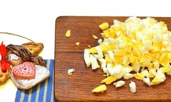 1. Этап. Сырный салат с яйцом: 2. Заранее отварите яйца вкрутую. Охладите их, почистьте от скорлупы, нарежьте кубиками и добавьте в салат.