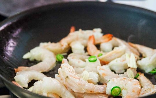 1. Этап. Креветки с чесноком и лаймом: 1. Поместите очищенные креветки в разогретую с растительным маслом сковороду. Добавьте в сковороду помытый и нарезанный чили.