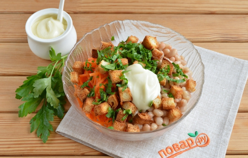 1. Этап. Салат с кириешками и фасолью: 2. В салатнике соедините морковь по-корейский, фасоль, кириешки, майонез и порезанную петрушку.