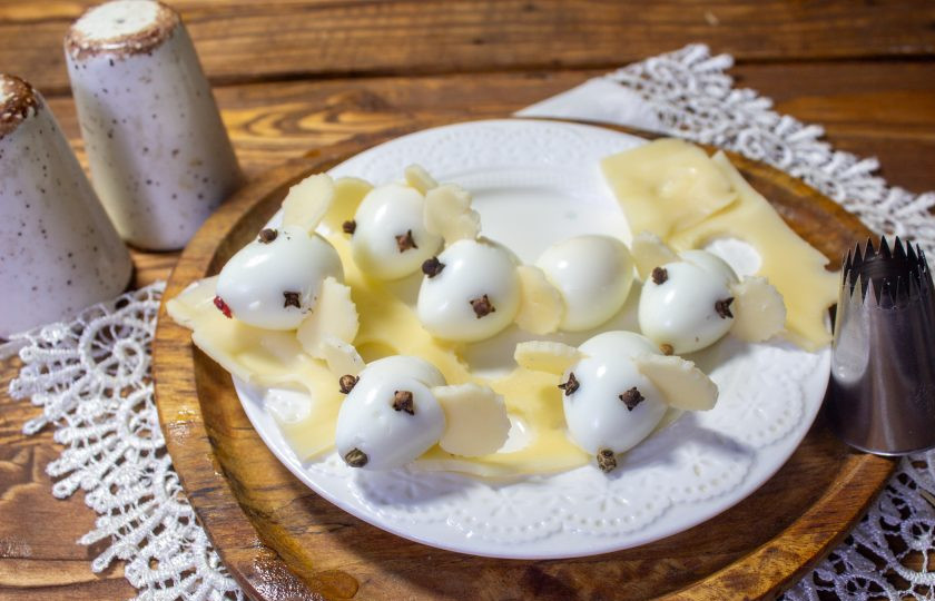 1. Этап. Салат Кусочек сыра: Из перепелиных яиц и кусочков сыра сделайте украшение для салата. Ушки сделайте из сыра, а глазки и носик — из гвоздики и горошин перца.