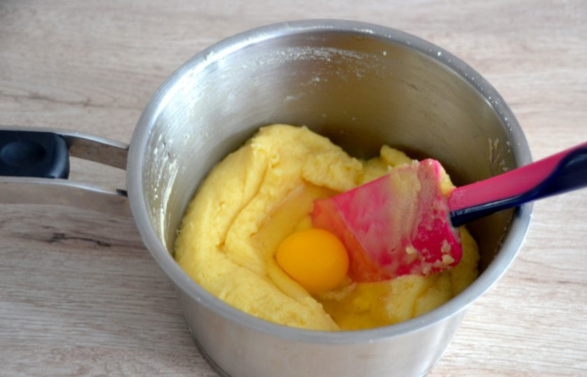 1. Этап. Профитроли с масляным кремом: Вливайте в тесто по одному яйцу, тщательно вмешивая каждое яйцо. Каждое последующее яйцо вливайте только тогда, когда полностью вмешаете предыдущее.