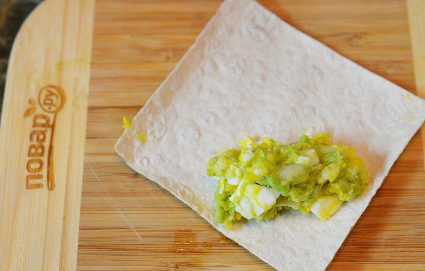 1. Этап. Рулетики из бекона с авокадо: Вырезаем из лаваша квадрат. На уголок выложите начинку из авокадо.