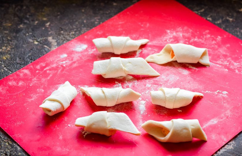 1. Этап. Слойки с мандаринами: Сверните заготовку, чтобы вышли рогалики.