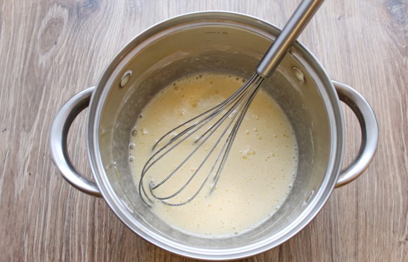 1. Этап. Польский медовик: Для начала приготовьте заварной крем со сгущенным молоком. В кастрюлю разбейте яйца, добавьте сахар и крахмал, перемешайте до однородности. Добавьте 1/4 часть молока и снова перемешайте.