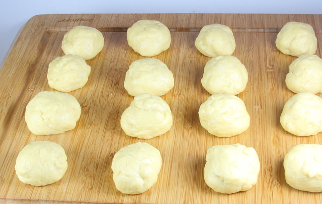 1. Этап. Перемяч: Когда тесто уже точно будет готово, мы приступаем непосредственно к лепке перемячей. От теста отрываем кусочки размером с небольшое яблоко и формируем из них шарики. Выкладываем их на ровную поверхность на расстоянии друг от друга, накрываем их полотенцем и оставляем на 20 минут.