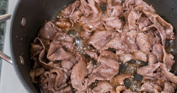 1. Этап. Говядина с лапшой Никудзяга: 1. Помойте и нарежьте тонкими ломтиками мясо. Почистите, нарежьте крупными кусочками лук и морковь. Нагрейте сковороду, добавьте в нее масло и сахар, затем выложите мясо и обжарьте.