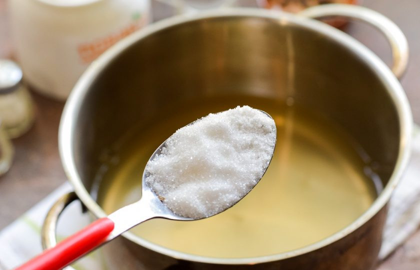 1. Этап. Огурцы с виноградными листьями на зиму: Спустя время слейте воду в кастрюлю, добавьте соль и сахар, проварите минуту и влейте уксус.