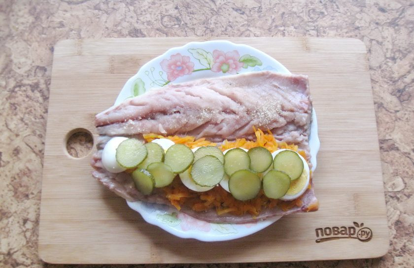 1. Этап. Холодная закуска из скумбрии: Маринованный или соленый огурец нарезать кружками и выложить на яйцо.