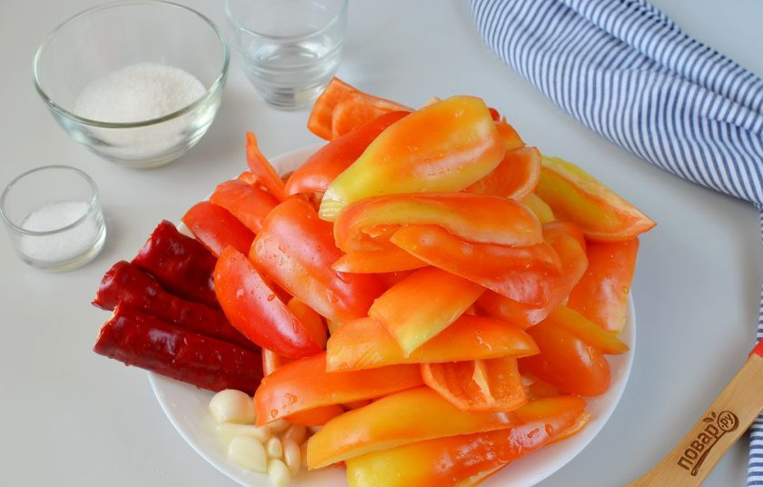 1. Этап. Аджика из перца болгарского на зиму: Очистите болгарский перец, удалите семена и порежьте на 4 части. У острого перца просто обрежьте хвостики. Очистите чеснок.
