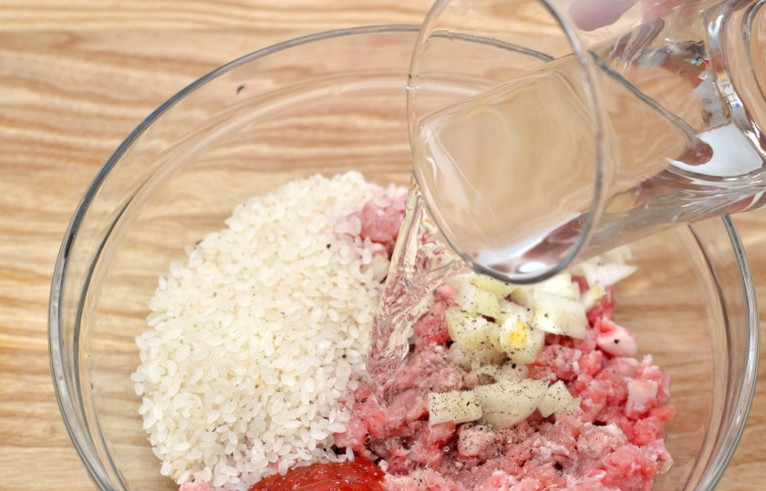 1. Этап. Долма с бараниной: Смешайте в чашке давленный чеснок, бараний фарш, томатный соус и рубленный лук. Посолите, поперчите душистым перцем и обычным чёрным. Добавьте 50 мл воды. Всё перемешайте.