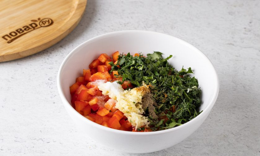 1. Этап. Холодная закуска из баклажанов с помидорами и чесноком: Мелко порубите зелень, а чеснок пропустите через пресс. Объедините овощи, чеснок и зелень. Добавьте уксус, растительное масло, острый молотый перец, соль и черный молотый перец.