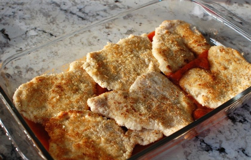 1. Этап. Куриные грудки с сыром в духовке: 8. Сперва переложите мясо на салфетку, чтобы впитался жир. Далее в форму для запекания выложите около 200 грамм соуса, поверх него уложите мясо.