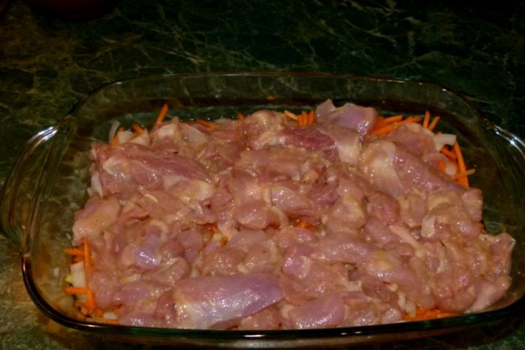 1. Этап. Плов в духовке с курицей: Сверху выкладываем курицу в горчице и оставшиеся косточки с мясом.