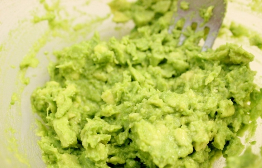 1. Этап. Бутерброды со шпротами и авокадо: Раздавите авокадо вилкой, добавьте лимонный сок, рубленый чеснок, соль и перец.