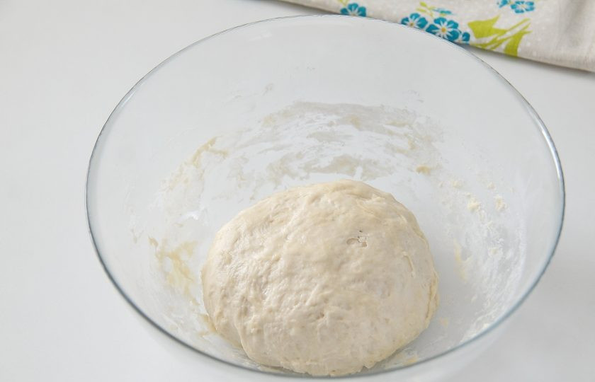 1. Этап. Простая пицца с луком: 5. Замесите руками мягкое и чуть липкое тесто. Соберите в шар и накройте полотенцем.