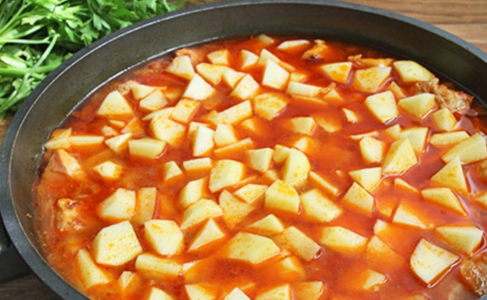 1. Этап. Тушеная картошка со свининой на сковороде: Также закладываем очищенный и порезанный кубиками картофель, солим и перчим. Тушим минут 25 до мягкости картошки.