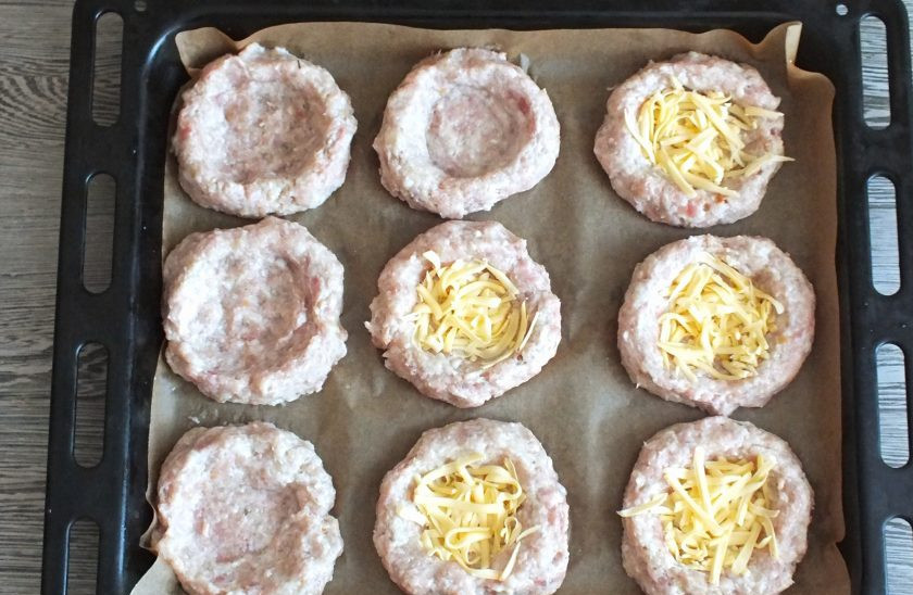 1. Этап. Мясные ватрушки с яйцом: Подготовленным мясным шарикам придайте форму ватрушек. В углубление разложите натёртый сыр.