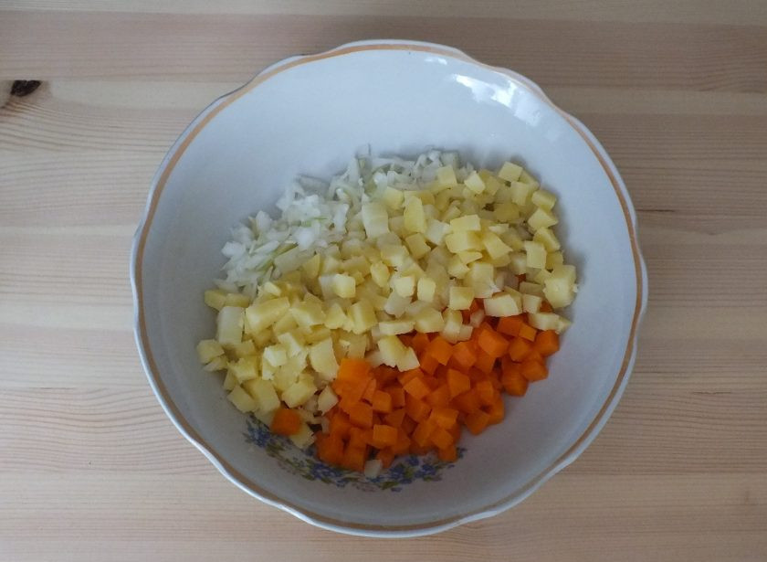 1. Этап. Оливье из красной рыбы: Возьмите глубокий салатник. Нарежьте средним кубиком картофель и морковь. Лук нарежьте мелким кубиком, слегка присолите и отожмите сок. Все овощи переложите в салатник.