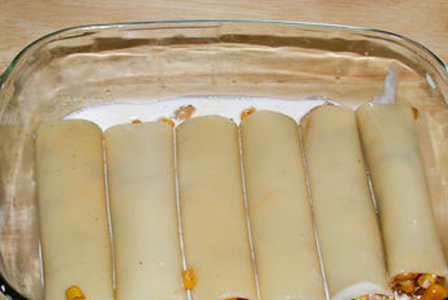 1. Этап. Каннеллони, фаршированные курицей и грибами: Приготовим соус – пассеруйте муку в сливочном масле, помешивая постепенно влейте молоко и доведите до кипения. Добавьте тертый сыр и мешайте до его полного расплавления. Поперчите и посолите. Выложенные в форму для запекания каннеллони залейте соусом.