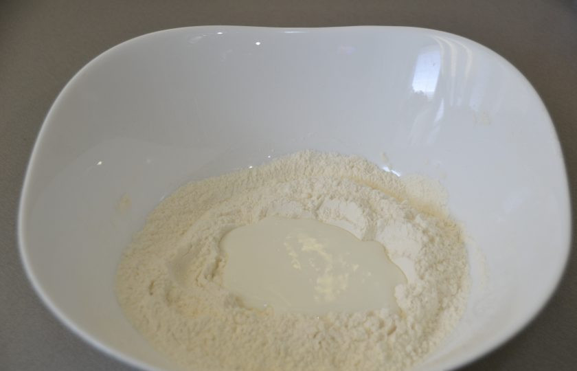 1. Этап. Хворост из жидкого теста: В муке сделайте углубление, влейте кефир или натуральный йогурт.