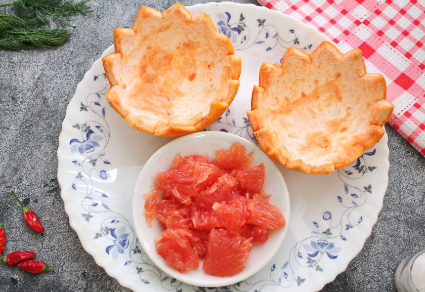 1. Этап. Салат с курицей в грейпфруте: Грейпфрут разрежьте на две половины. Острым ножом проведите вдоль корки и, помогая себе столовой ложкой, достаньте мякоть, не повреждая кожуру. На краях половинок кожуры вырежьте зубчики. Мякоть вырежьте ножом между пленками и разрежьте на кусочки.