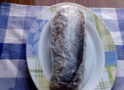 1. Этап. Закуска из сельди к праздничному столу: Закручиваем закуску в пленку, как рулет, и отправляем в холодильник на пару часов, в идеале — на ночь.