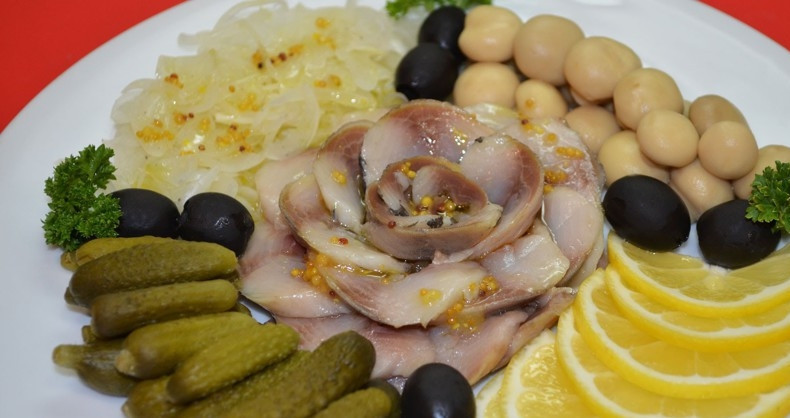 1. Этап. Нарезка из селедки на праздничный стол: Посередине блюда для сервировки выложите рыбу. С одной стороны уложите лук, а с другой дольки лимона. Также выложите корнишоны, оливки и шампиньоны. Украсьте закуску петрушкой, полейте всё соусом. Вкусной вам дегустации!