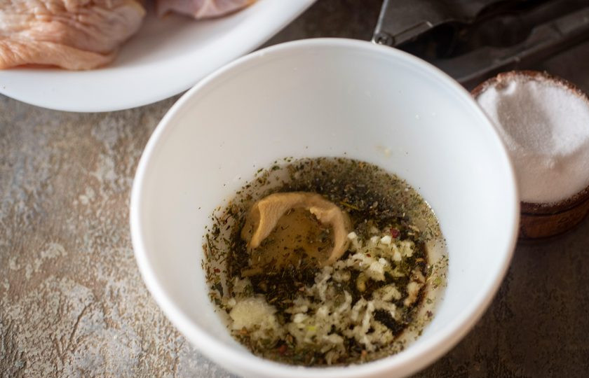 1. Этап. Куриные бедра в аэрогриле: Выдавите в эту мисочку зубчики чеснока через чеснокодавилку, добавьте соль, горчицу, хмели-сунели. Все перемешайте. Маринад готов.