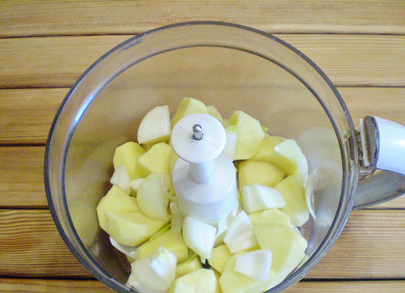 1. Этап. Драники рецепт классический: 2. Картофель нарезаем небольшими кусочками, складываем их в измельчитель. Добавляем порезанную луковицу, солим по вкусу.