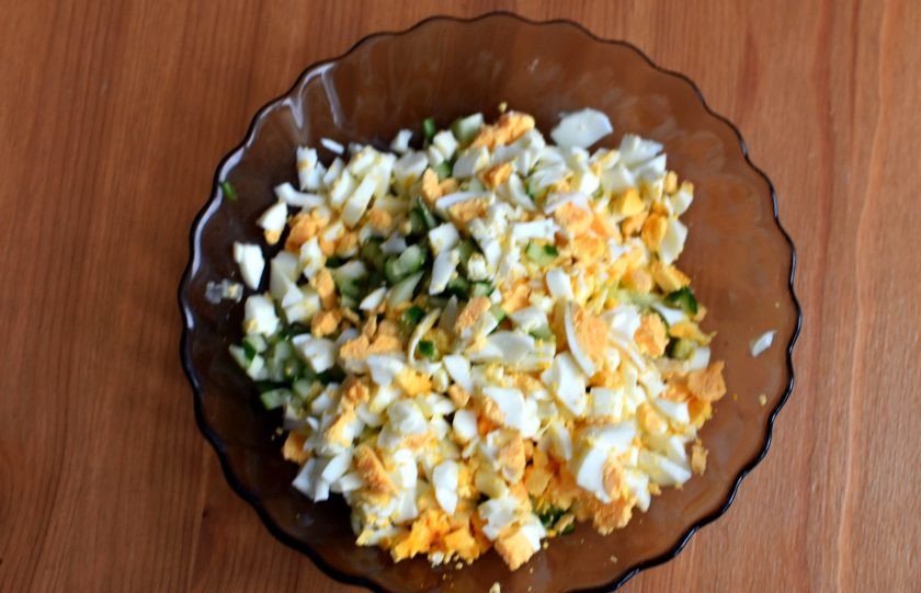 1. Этап. Тарталетки с рыбным салатом: Отварите яйца вкрутую, остудите и очистите. Нарежьте яйца мелкими кубиками. Так же нарежьте свежий огурец. Добавьте нарезанные мелкими кубиками сыр и вяленые в масле помидоры. Заправьте салат зерновой горчицей и лимонным соком, поперчите по вкусу и перемешайте.