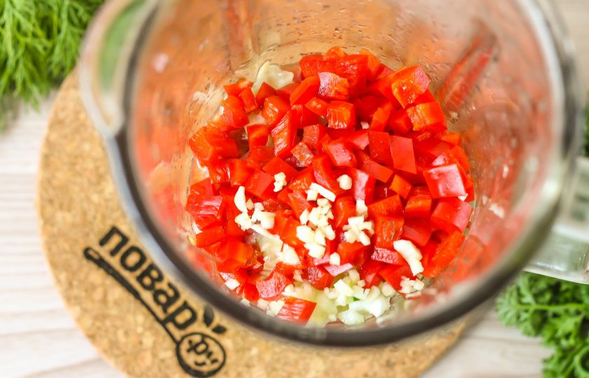 1. Этап. Гаспачо по-андалузски: Болгарский перец очистите от семян и промойте, нарежьте мелким кубиком. Если не любите, чтобы шкурка овоща попадалась в супе, то предварительно запеките перец и очистите его от кожуры и семян. Очистите и зубчики чеснока, промойте, измельчите. Добавьте обе нарезки в емкость.