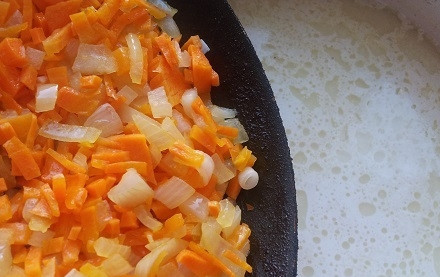 1. Этап. Сырный суп со свининой: 5. Луковицу и морковь очищаем и моем. Лук нарезаем мелким кубиком, а морковь трем на терке. На сковороде обжариваем овощи до готовности, после чего добавляем их в бульон.